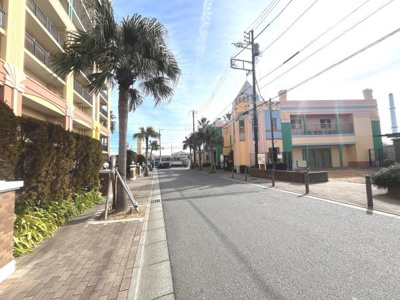 ヤシの木が並ぶ歩道が印象的な街並みです。建物の外観がカラフルで個性的です。道路が広めで開放感があります。歩道も整備されており安心して歩くことができます。植栽も手入れされていて清潔感があります。