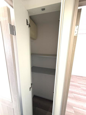 扉付きの収納スペースが設けられています。室内にすっきりと収まる設計です。棚が設置されているため使い分けもしやすい収納です。スペースがしっかり確保されています。