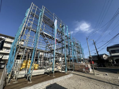 建築中の現場は開放感のある外観が特徴です。周囲には住宅が立ち並び落ち着いた雰囲気のエリアです。青空が広がり日当たりの良さを感じます。敷地も広く今後の完成が楽しみな建物です。