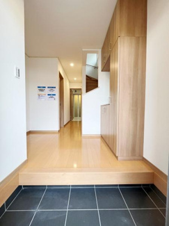 広々とした玄関は明るく清潔感があります。床と収納の木目が調和して落ち着いた印象です。収納スペースも充実しており使い勝手が良さそうです。玄関から室内への動線がスムーズです。