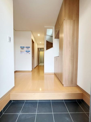 広々とした玄関は明るく清潔感があります。床と収納の木目が調和して落ち着いた印象です。収納スペースも充実しており使い勝手が良さそうです。玄関から室内への動線がスムーズです。