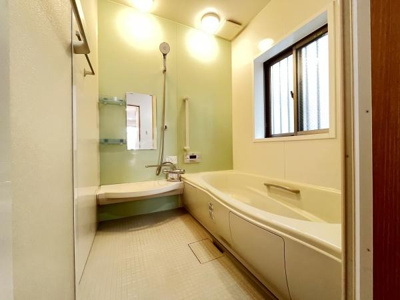 浴室内は明るく広がりを感じる空間です。大きな窓があり換気や採光に配慮されています。手すりも設置されており安心感があります。シンプルなデザインが魅力的です。