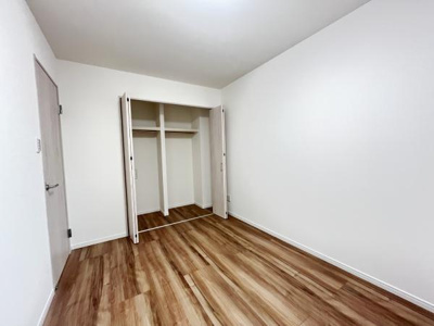 シンプルな内装が印象的な洋室です。使いやすいクローゼットが備わっています。温かみのあるフローリングが空間を引き立てます。壁や扉も明るい色調で清潔感があります。