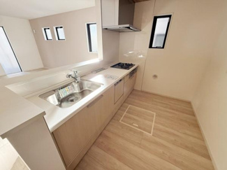 ナチュラルな木目調が特徴のキッチンです。窓が多く明るい空間となっています。作業スペースが広くシンプルなデザインで手入れも簡単です。IHコンロが設置されており収納も充実しています。