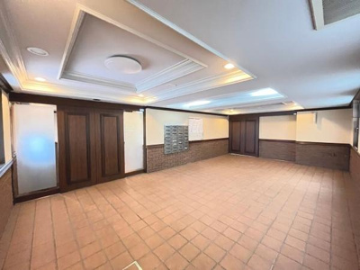 広々としたエントランスが印象的です。天井のデザインが上品な雰囲気を演出しています。郵便受けも設置されており使い勝手に配慮されています。照明がしっかりと配置されているため明るさを感じられます。